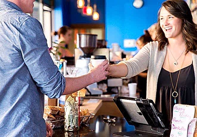 Matt Konen taking a cup of coffee from a barista in Bozeman, MT