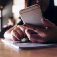 woman holding an ipad looking at analytics information and graphs surrounded by two other people looking at the data